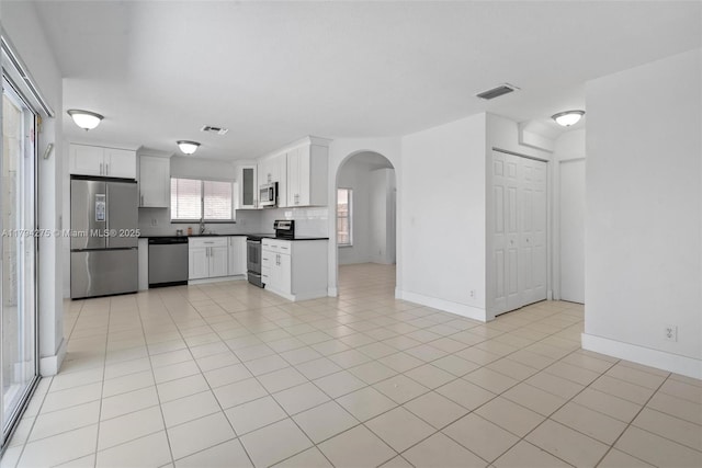 6813 Torch Key St, Lake Worth, FL 33467 - kitchen featuring dark countertops, arched walkways, stainless steel appliances, and visible vents