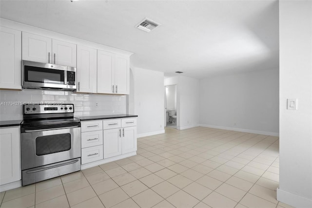 6813 Torch Key St, Lake Worth, FL 33467 - kitchen with baseboards, tasteful backsplash, dark countertops, and stainless steel appliances