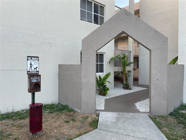 doorway to property featuring stucco siding and a balcony
