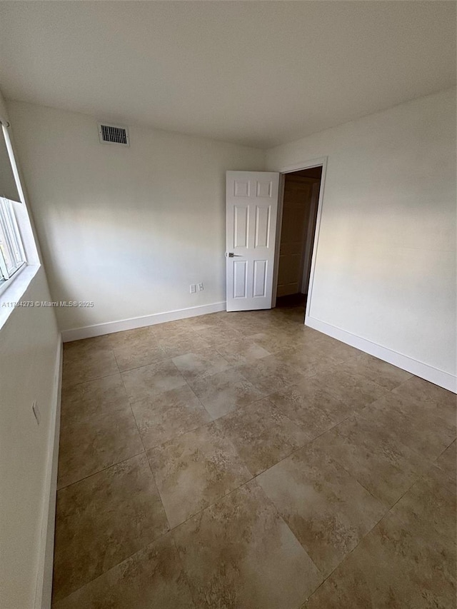 empty room with visible vents and baseboards