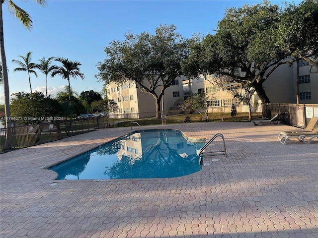 pool featuring fence and a patio area