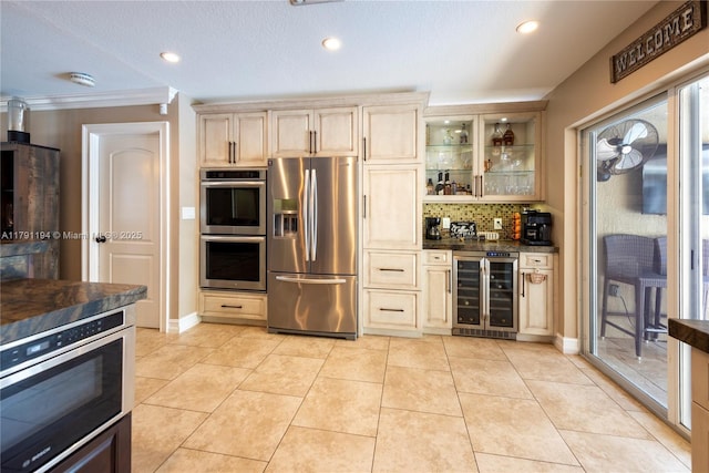 kitchen with stainless steel appliances, tasteful backsplash, wine cooler, glass insert cabinets, and dark countertops