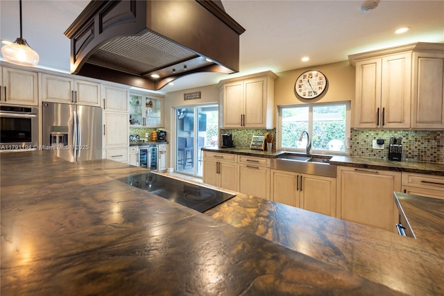 kitchen with a sink, a wealth of natural light, appliances with stainless steel finishes, decorative backsplash, and custom exhaust hood