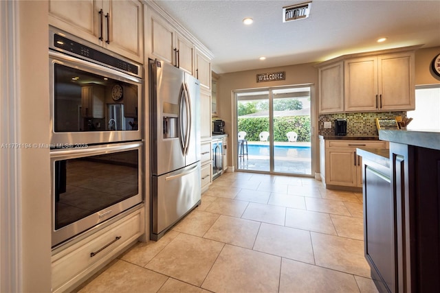 kitchen featuring backsplash, recessed lighting, stainless steel appliances, and visible vents