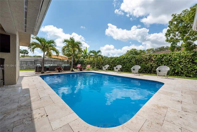 view of swimming pool with a fenced backyard, a patio area, a fenced in pool, and outdoor lounge area