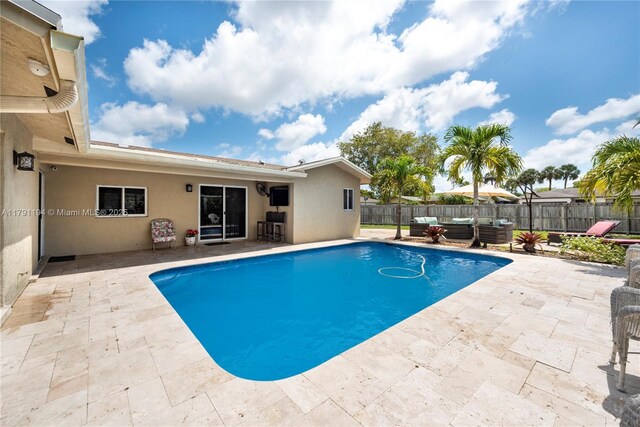 view of pool with an outdoor living space, a patio area, a fenced in pool, and a fenced backyard