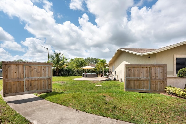 view of yard with a patio, fence, and a gate