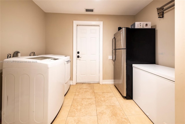laundry room with laundry area, light tile patterned flooring, separate washer and dryer, and visible vents