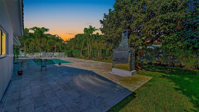 8195 SW 151st St, Palmetto Bay, FL 33158 - patio terrace at dusk with a lawn, fence, and a fenced in pool