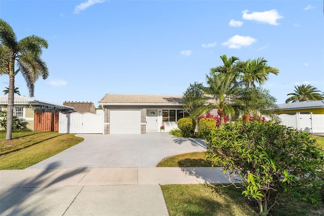ranch-style home featuring fence, a garage, a gate, concrete driveway, and a tiled roof