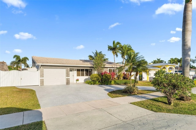 ranch-style home featuring a garage, stucco siding, a gate, a tiled roof, and driveway
