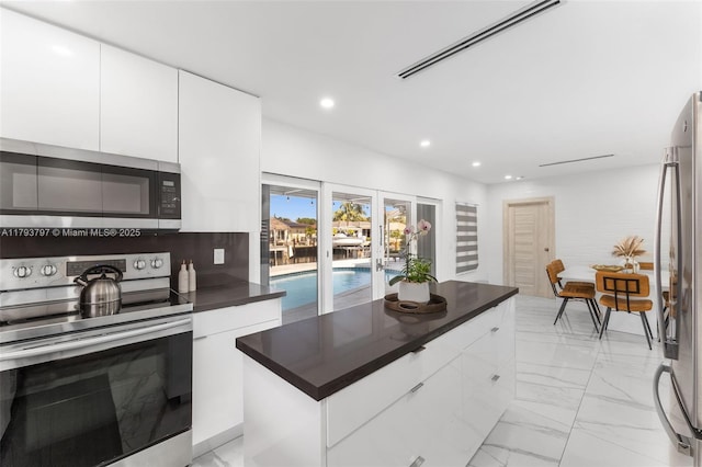 kitchen featuring white cabinetry, appliances with stainless steel finishes, modern cabinets, and dark countertops