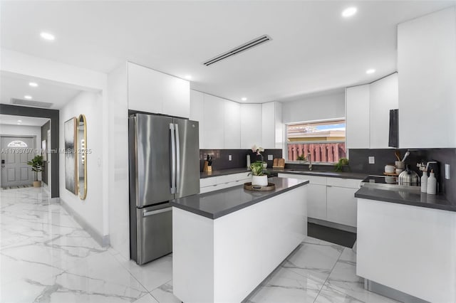 kitchen featuring visible vents, dark countertops, freestanding refrigerator, marble finish floor, and recessed lighting