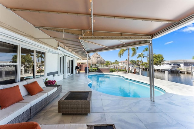 pool with an outdoor hangout area, a water view, and a patio area