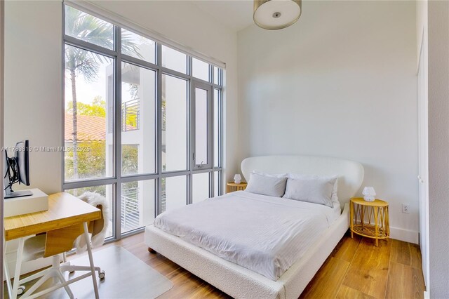 bedroom featuring light wood-style floors and an office area
