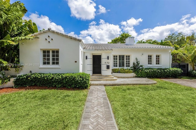 712 NE 72nd St, Miami, FL 33138 - view of front facade featuring a tile roof, stucco siding, a front yard, and a chimney