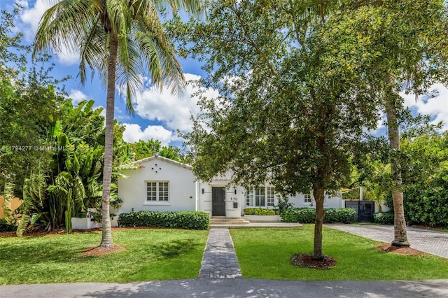 712 NE 72nd St, Miami, FL 33138 - exterior space featuring a front lawn, stucco siding, a chimney, and fence