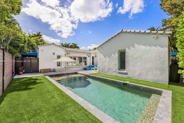 712 NE 72nd St, Miami, FL 33138 - rear view of property featuring a yard, a fenced in pool, a fenced backyard, and stucco siding