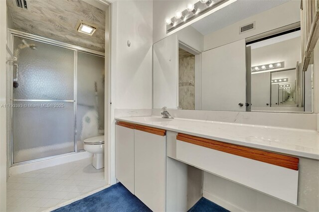 bathroom with tile patterned flooring, vanity, toilet, visible vents, and a stall shower