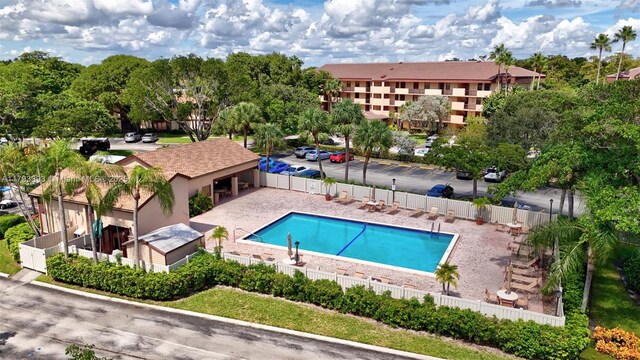 community pool with fence and a patio area