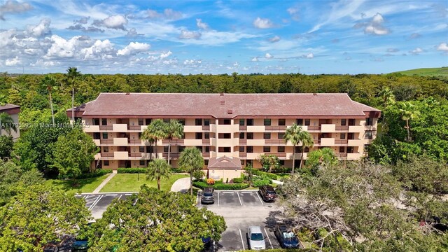 birds eye view of property featuring a view of trees