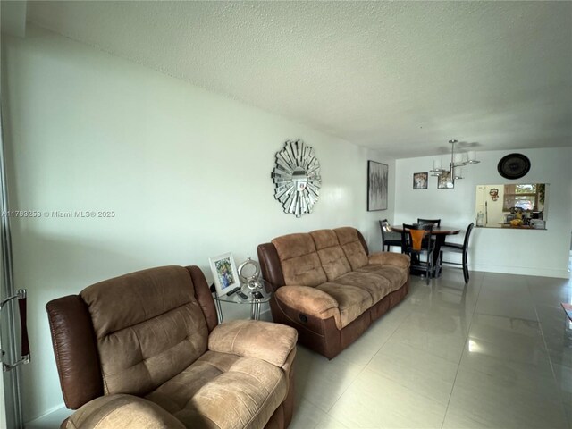 1680 NE 191st St Unit 118-2, Miami, FL 33179 - living room with a textured ceiling, an inviting chandelier, and light tile patterned floors