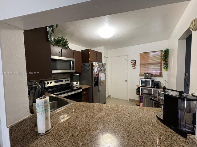 1680 NE 191st St Unit 118-2, Miami, FL 33179 - kitchen featuring a sink, appliances with stainless steel finishes, dark brown cabinetry, and light tile patterned flooring