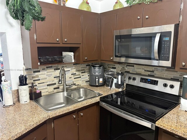 1680 NE 191st St Unit 118-2, Miami, FL 33179 - kitchen featuring dark brown cabinets, appliances with stainless steel finishes, a sink, light countertops, and backsplash