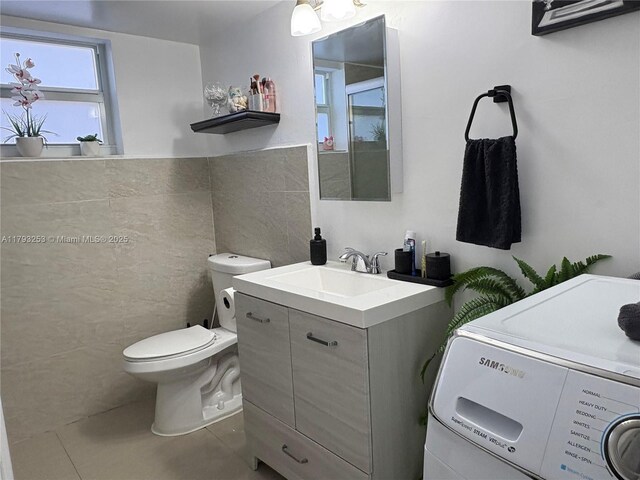 1680 NE 191st St Unit 118-2, Miami, FL 33179 - bathroom with vanity, toilet, tile walls, washer / clothes dryer, and tile patterned floors