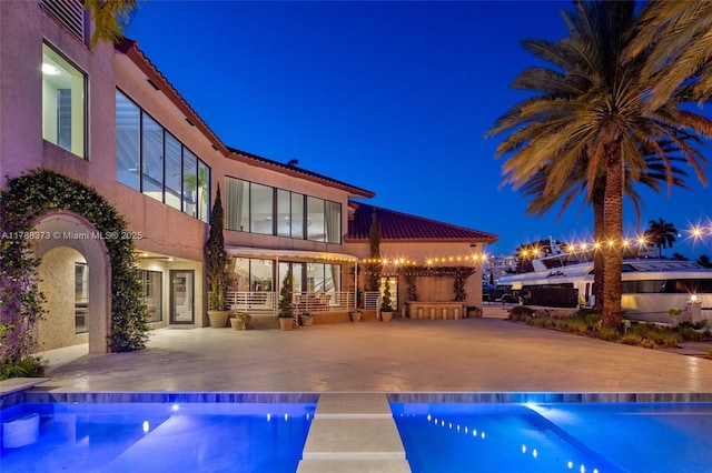 600 Isle Of Palms Dr, Fort Lauderdale, FL 33301 - back of house at twilight with an outdoor pool and a patio area