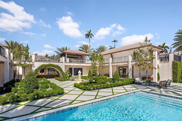 600 Isle Of Palms Dr, Fort Lauderdale, FL 33301 - rear view of property featuring a tile roof, an outdoor pool, a balcony, a patio, and stucco siding