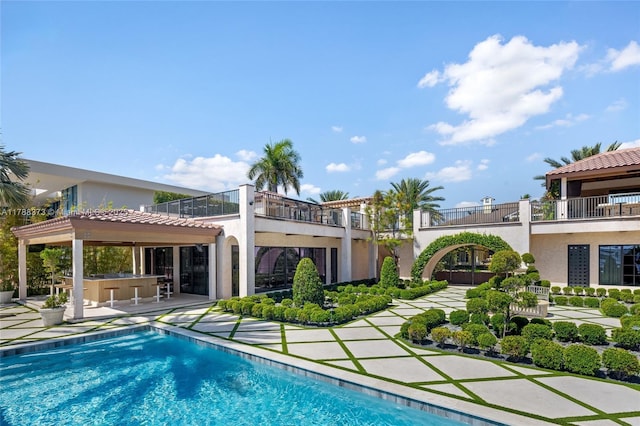 600 Isle Of Palms Dr, Fort Lauderdale, FL 33301 - rear view of house featuring a balcony, outdoor dry bar, stucco siding, and an outdoor pool