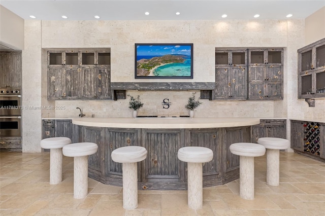 600 Isle Of Palms Dr, Fort Lauderdale, FL 33301 - bar featuring recessed lighting, stainless steel double oven, wet bar, and decorative backsplash