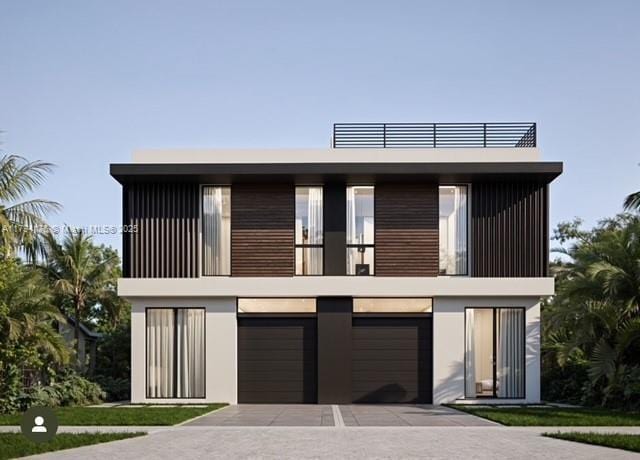 contemporary home with an attached garage, driveway, a balcony, and stucco siding