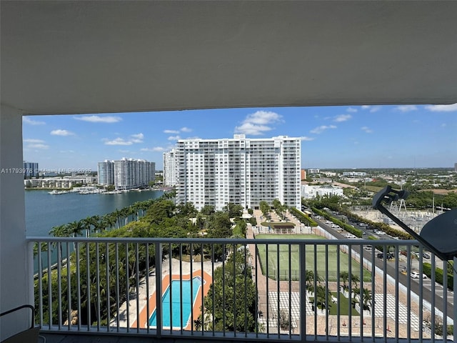 balcony with a water view and a view of city