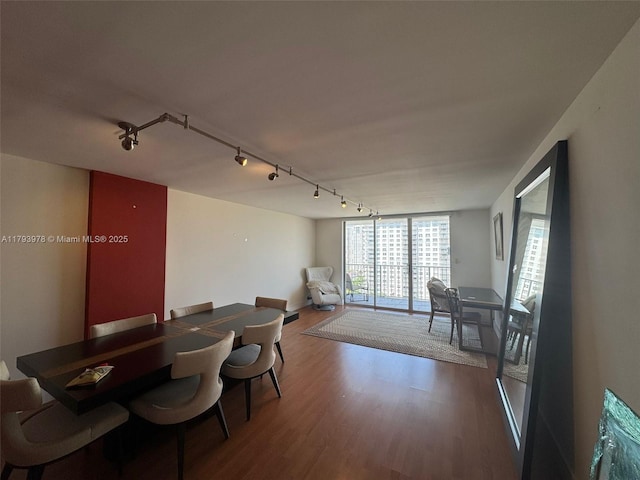 dining space with rail lighting and wood finished floors