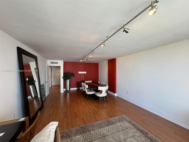 dining area featuring track lighting, baseboards, wood finished floors, and visible vents