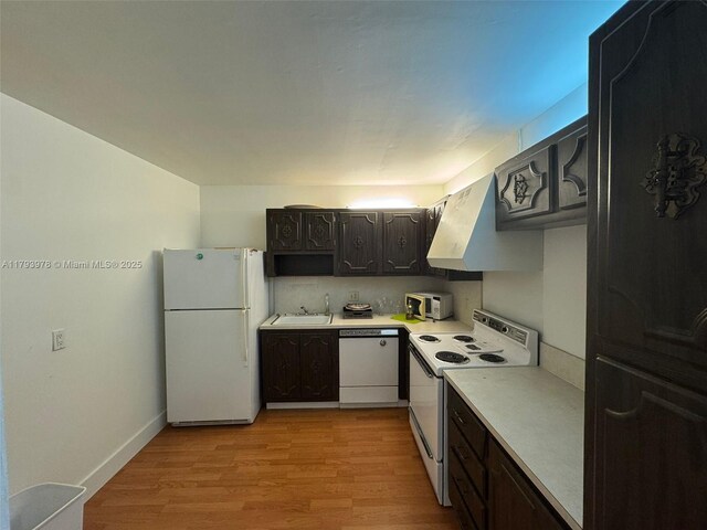2851 NE 183rd St Unit 1408E, Aventura, FL 33160 - kitchen featuring a sink, light wood finished floors, white appliances, light countertops, and under cabinet range hood