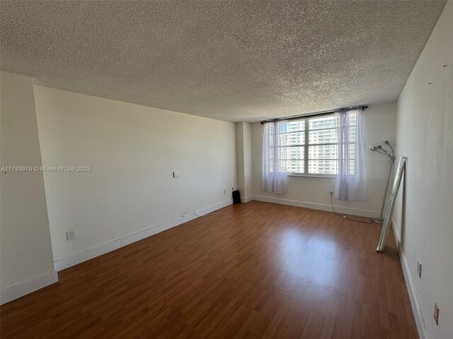 2851 NE 183rd St Unit 1408E, Aventura, FL 33160 - spare room featuring baseboards, a textured ceiling, and wood finished floors