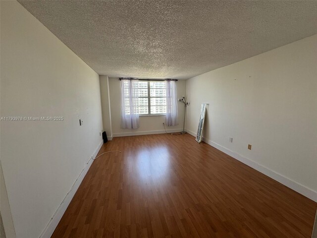 2851 NE 183rd St Unit 1408E, Aventura, FL 33160 - empty room featuring baseboards, a textured ceiling, and wood finished floors