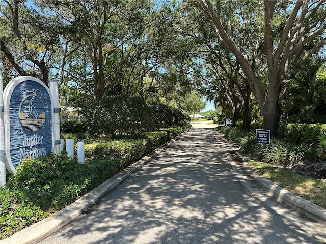 10737 SE Seaspray Ct, Hobe Sound, FL 33455 - view of asphalt road featuring curbs