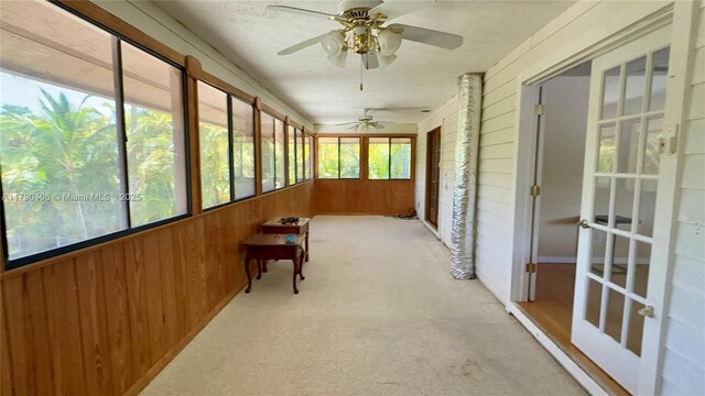 10737 SE Seaspray Ct, Hobe Sound, FL 33455 - unfurnished sunroom with wood walls and carpet floors