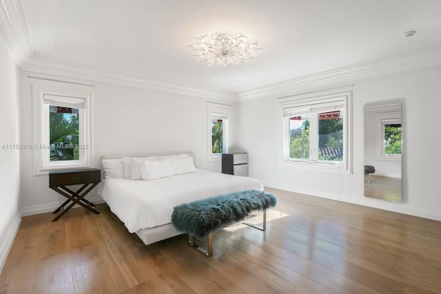 bedroom with multiple windows, ornamental molding, and wood finished floors