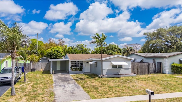 6501 Scott St, Hollywood, FL 33024 - view of front facade featuring fence, driveway, and a front yard