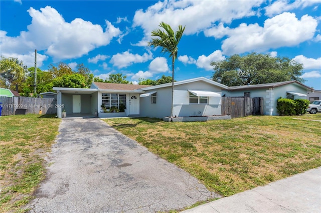 6501 Scott St, Hollywood, FL 33024 - single story home with aphalt driveway, a carport, fence, a front lawn, and stucco siding
