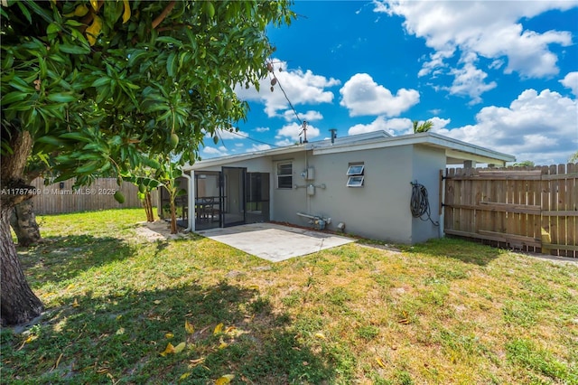 6501 Scott St, Hollywood, FL 33024 - back of property featuring stucco siding, a sunroom, a fenced backyard, a patio area, and a yard