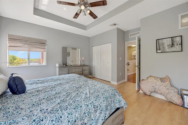 22221 SW 87th Pl, Cutler Bay, FL 33190 - bedroom featuring visible vents, light wood finished floors, and a tray ceiling