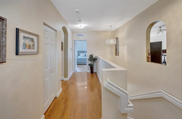 22221 SW 87th Pl, Cutler Bay, FL 33190 - hallway featuring arched walkways, baseboards, wood finished floors, and visible vents