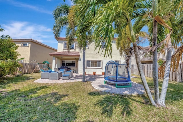 22221 SW 87th Pl, Cutler Bay, FL 33190 - rear view of house featuring outdoor lounge area, a patio, a fenced backyard, stucco siding, and a trampoline