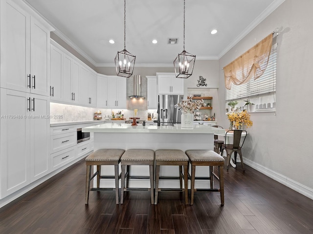 973 NE 36th Ave, Homestead, FL 33033 - kitchen featuring wall chimney range hood, stainless steel appliances, a kitchen bar, and a chandelier